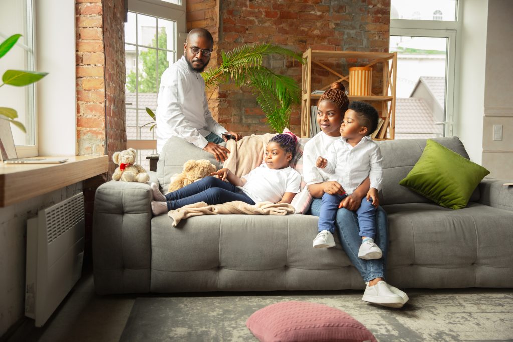 Parents avec enfants sur canapé dans un habitat confortable